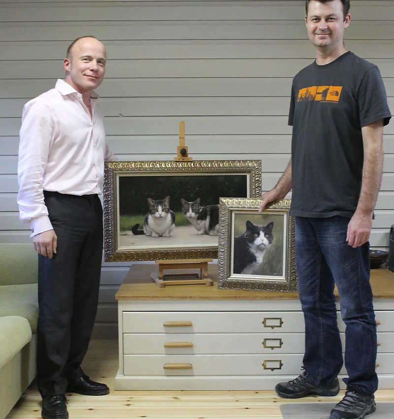 Happy client Alan with Purdy's beautifully framed cat portrait in the artist's studio.