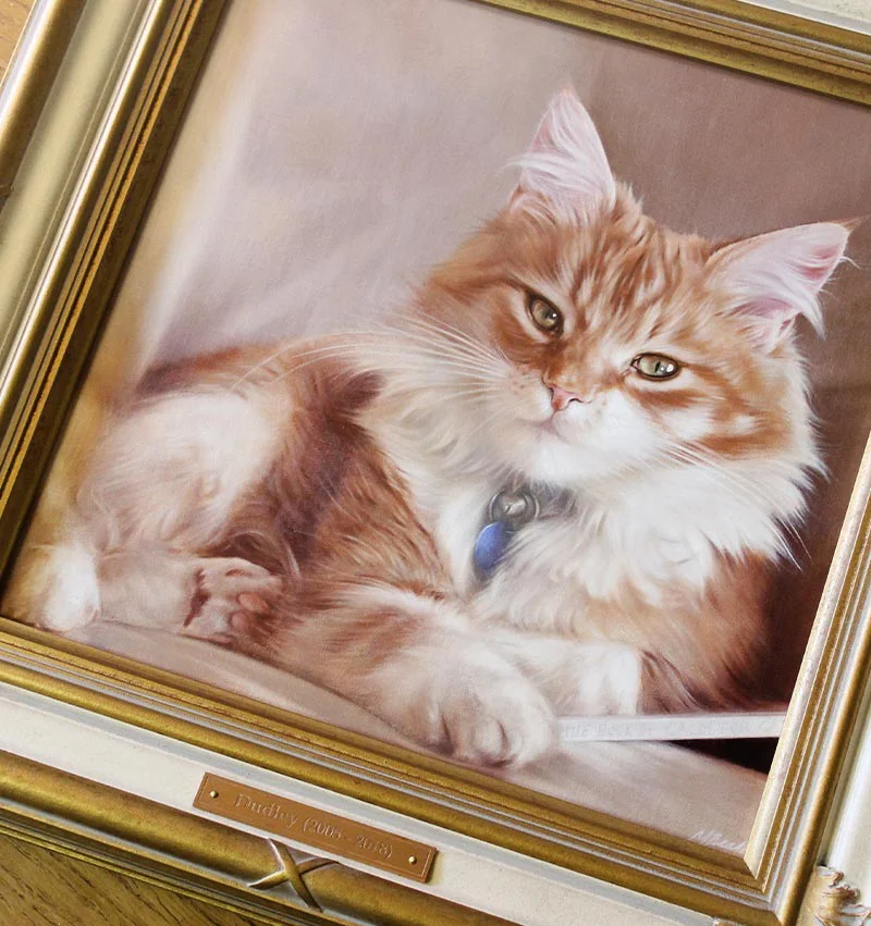 Dudley's framed cat oil portrait hanging elegantly on a wall.