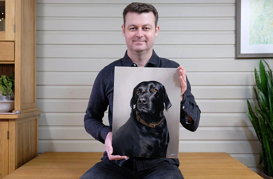 Oil painting of Bryher the Black Labrador on an artist's easel in a studio.
