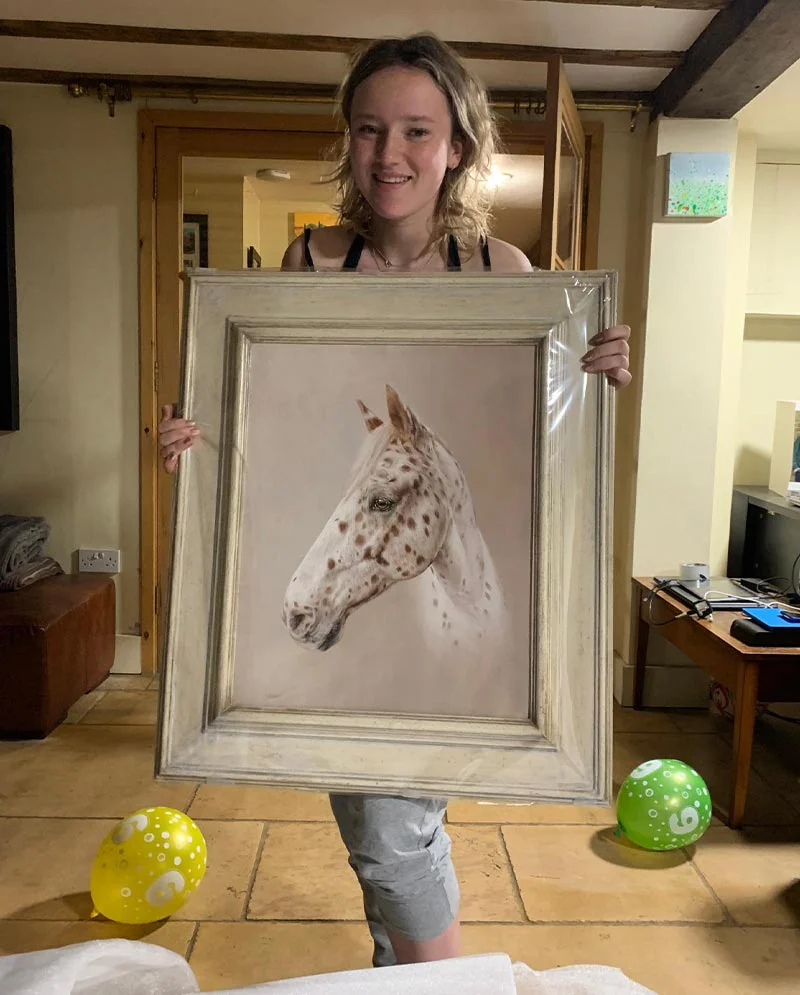 Client Holding Horse Portrait on Her Birthday Client holding her horse portrait of Henry on her birthday, showing her delight.