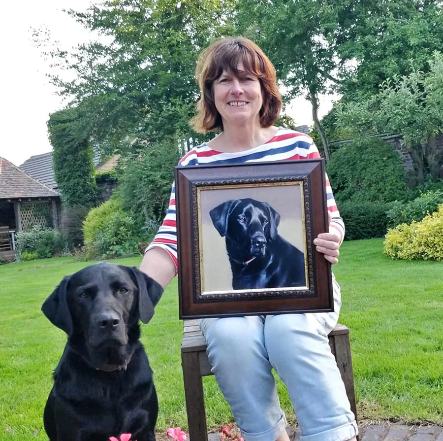 Mia: Birthday oil portrait of the Labrador with her owner Mia the black Labrador proudly sitting with her framed birthday portrait and owner