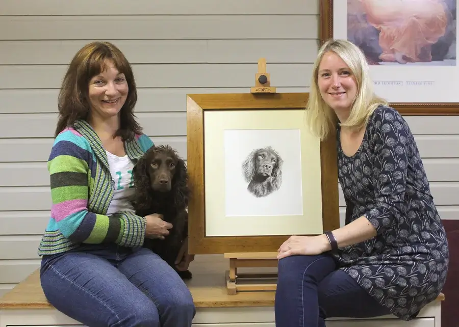 Pencil drawing of Moo, framed with Melanie and Tarcey and Moo in our studio.