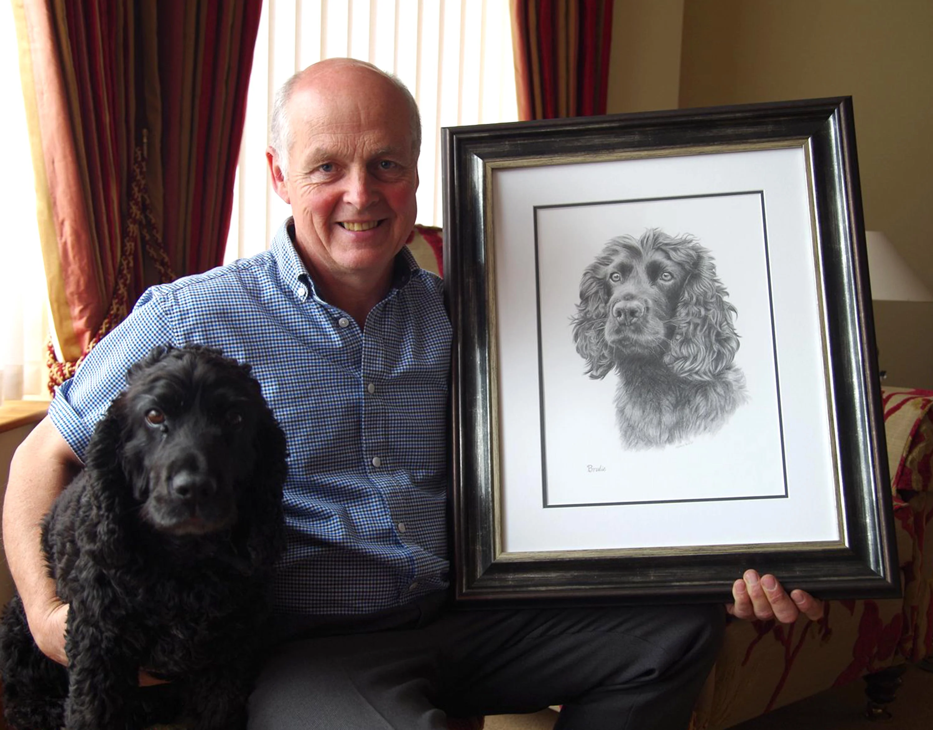 Lifelike Cocker Spaniel Dog Drawing in Pencil by Melanie Phillips Classic pencil portrait of Brodie, a Cocker Spaniel, capturing his curled fur and expressive face, with graphite pencils placed on the left.