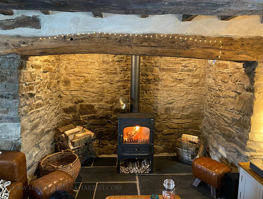 Inglenook Fireplace in Our Welsh Cottage Cozy inglenook fireplace with large oak beams and festive star lights in Nicholas and Melanie’s Welsh cottage at Christmas.
