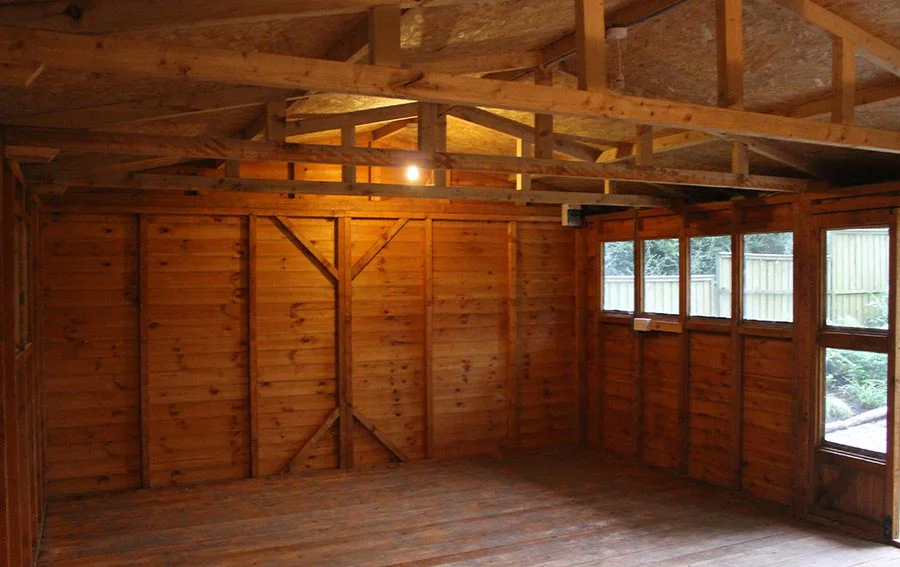 The initial stage of the studio renovation, showing the old workshop interior with the floor removed for insulation.