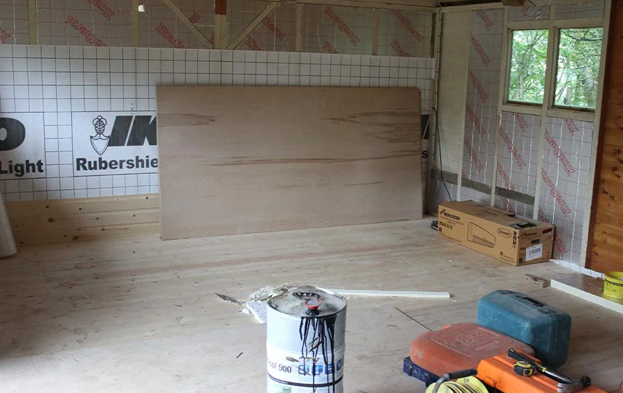 Studio walls being fitted with insulation bats and prepared for the installation of tongue and groove wood paneling.