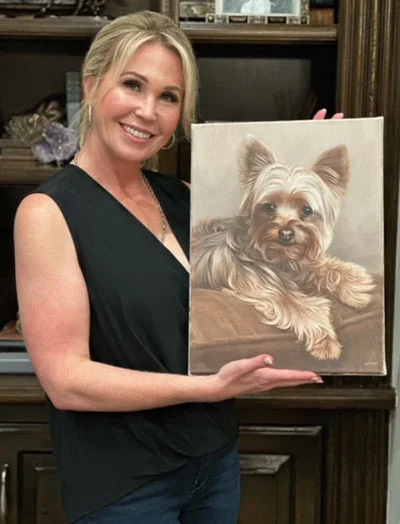 Client testimonial photo - Tiffany with Wendel's oil portrait Tiffany smiling with her custom oil portrait of her dog, Wendel, by Nicholas Beall